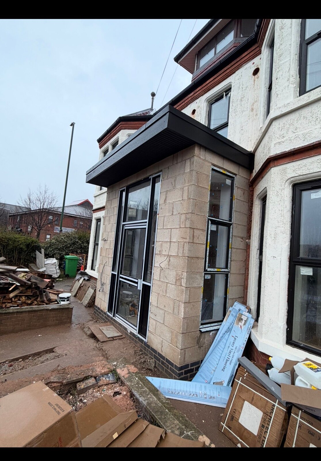 Blockwork side extension with flat roof and new windows in progress