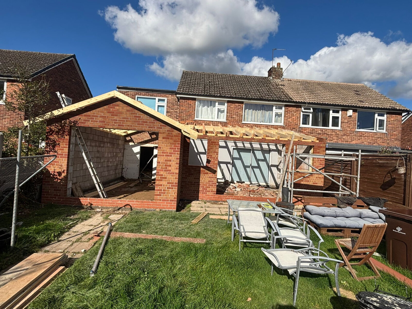 Single storey rear extension in red brickwork with new roof timbers being built on a Derby home