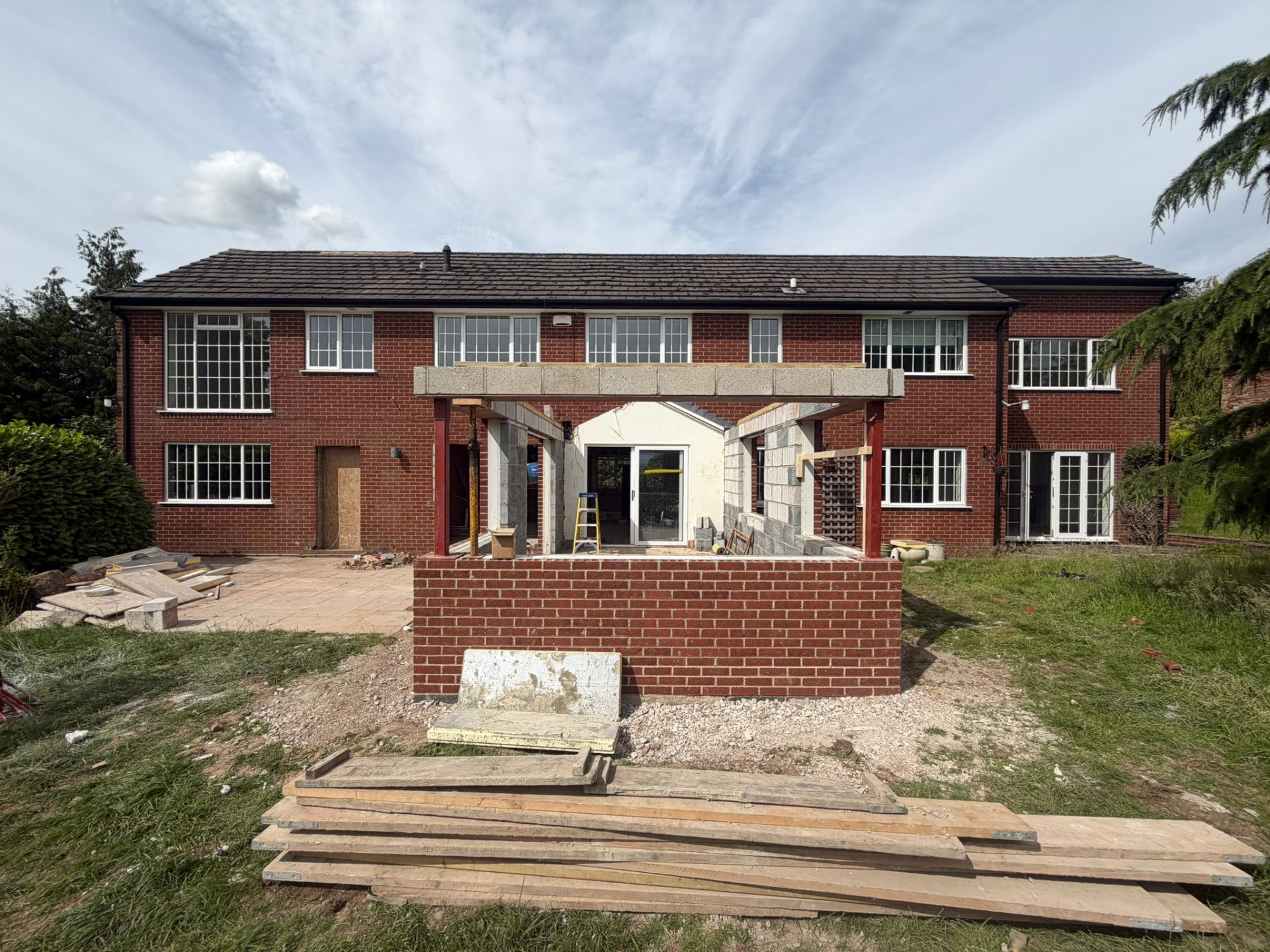 Large red brick property undergoing renovation with new structural openings