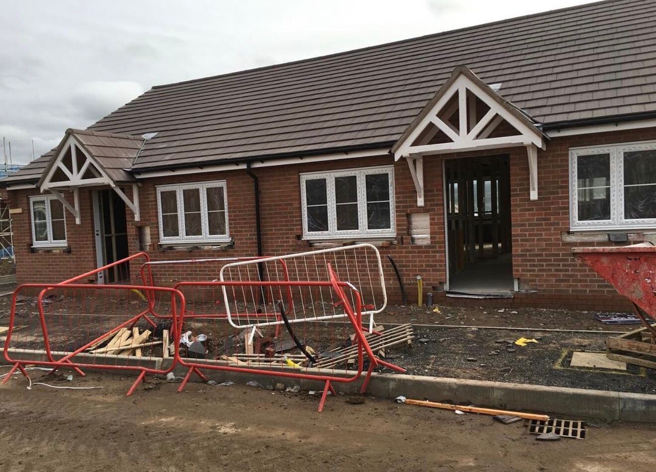 New build brick bungalows with pitched tiled roofs and timber entrance porches
