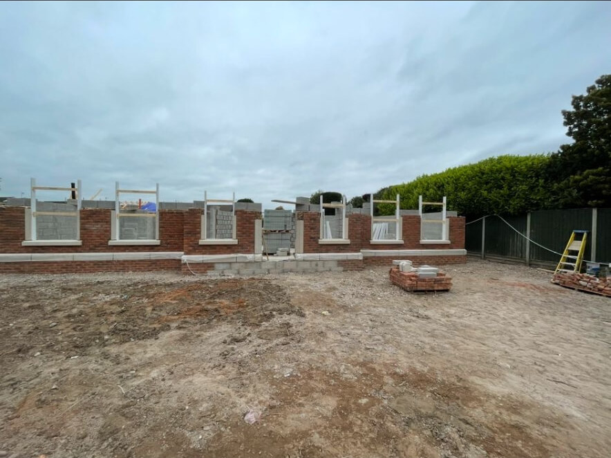 Ground floor brickwork and window openings set out on a new build plot in Bramcote