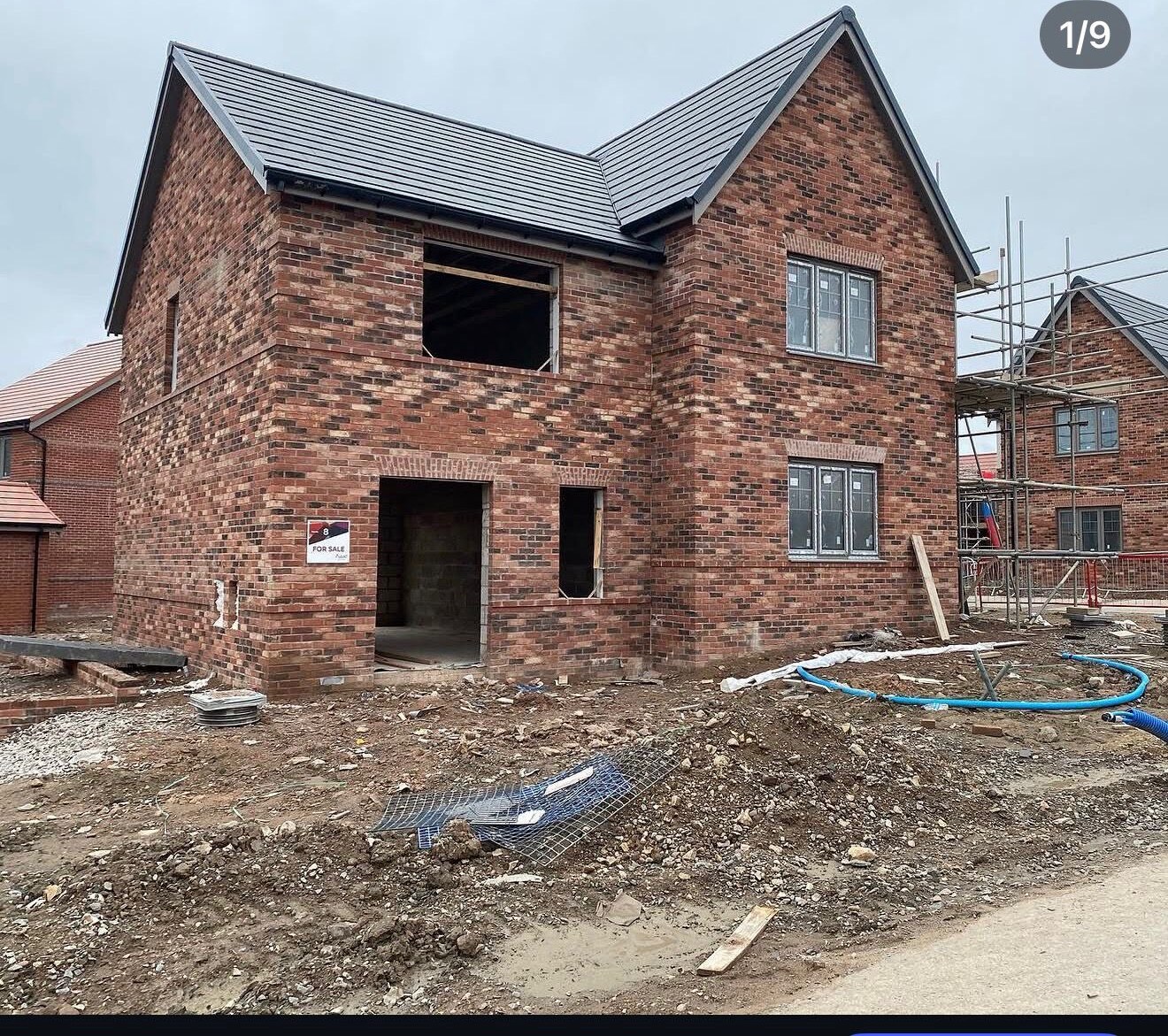 Multi red brick detached new build under construction with arched openings