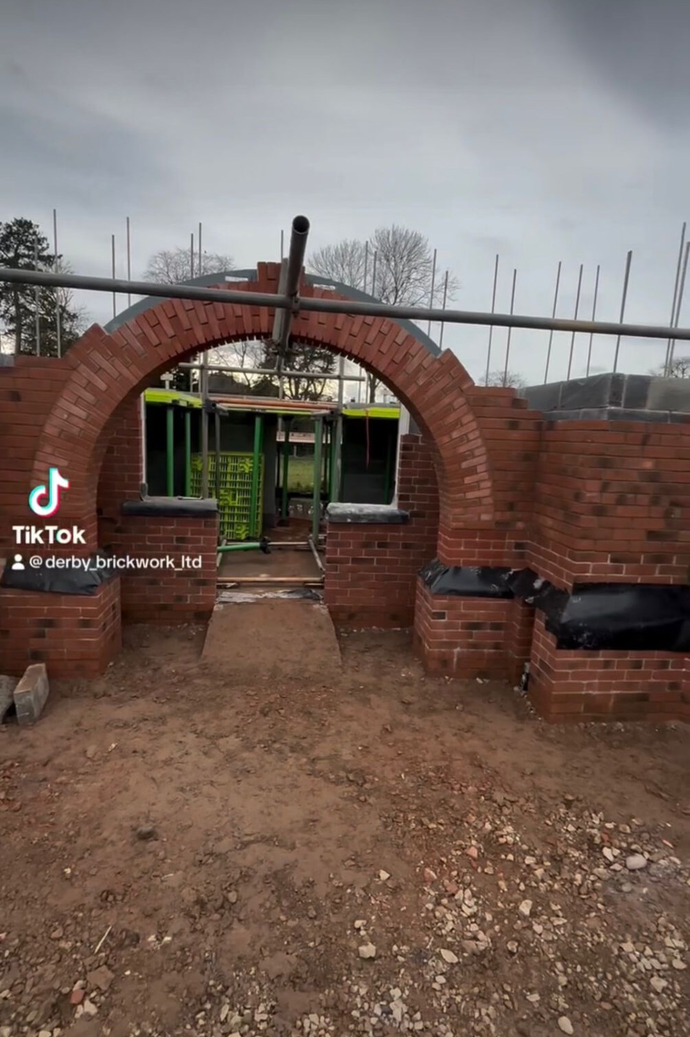 Large curved brick arch formed in red facing brickwork during construction