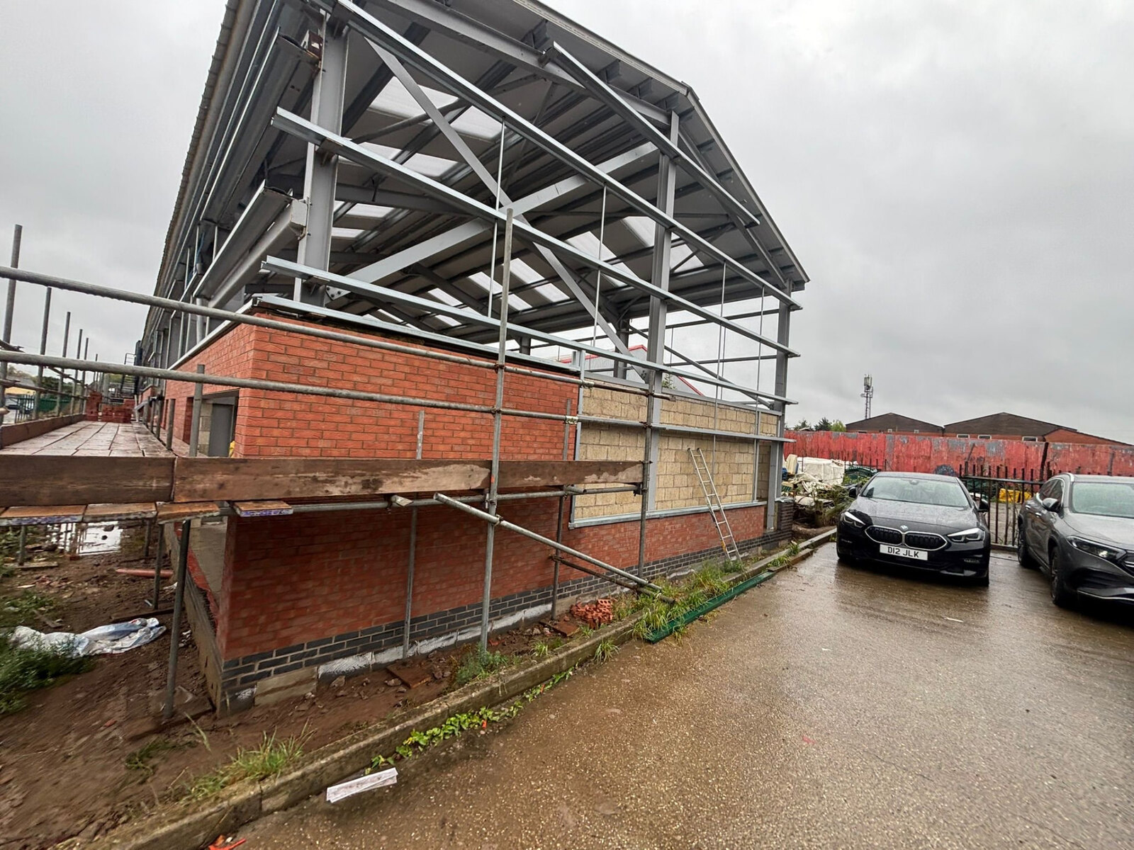 Commercial steel portal frame building with red facing brickwork and blockwork inner leaf