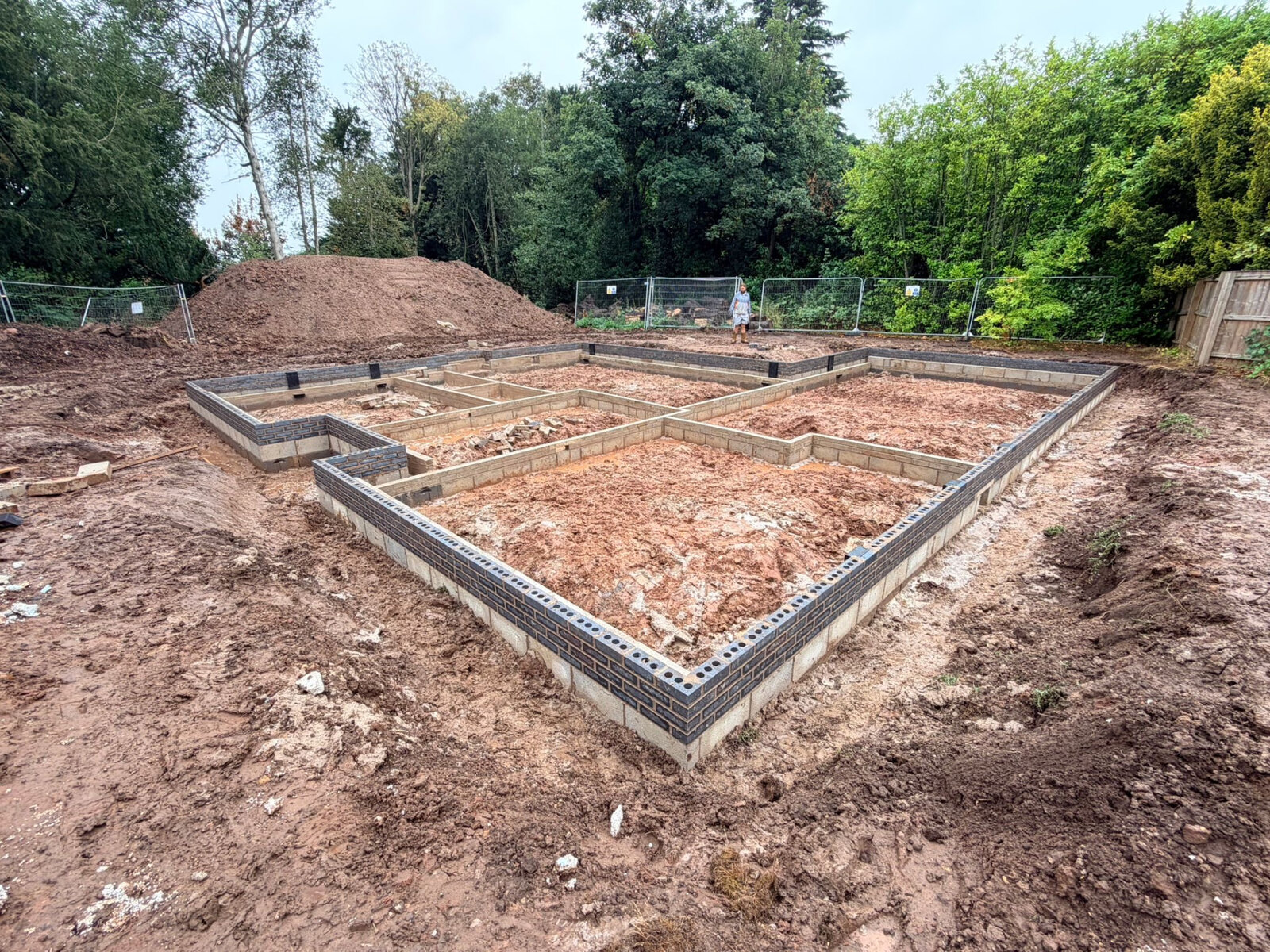 New build substructure walls in blockwork with blue brick courses to damp proof course level