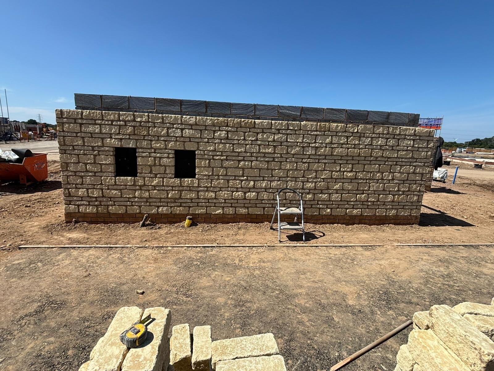 Reconstituted stone garden wall built on a new build development site with coping ready to be laid